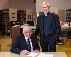 Board Chairman Rev. Robert Krestick and President Thomas Winger sign the agreement